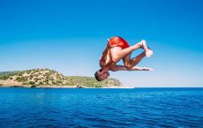 Mann springt Salto beim Baden beim segeln in Korfu mit Korfu Segeln