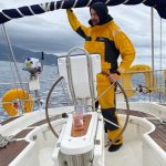 Yoga Sailing Retreat with skipper mathias on the wheel in full gear