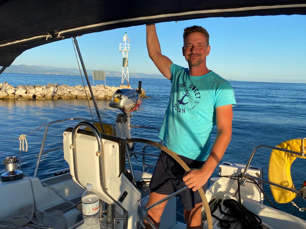 Yoga Sailing Retreat with skipper mathias smiling on the wheel