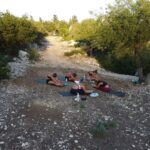 Yoga Segeln am Spot Mongonissi, Yoga-Gruppe hat ein schattiges Plätzchen inmitten des Olivenhains gefunden
