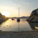 Yoga Sailing Retreat with yoga spot porto timoni south bay with sailing yacht at sunrise